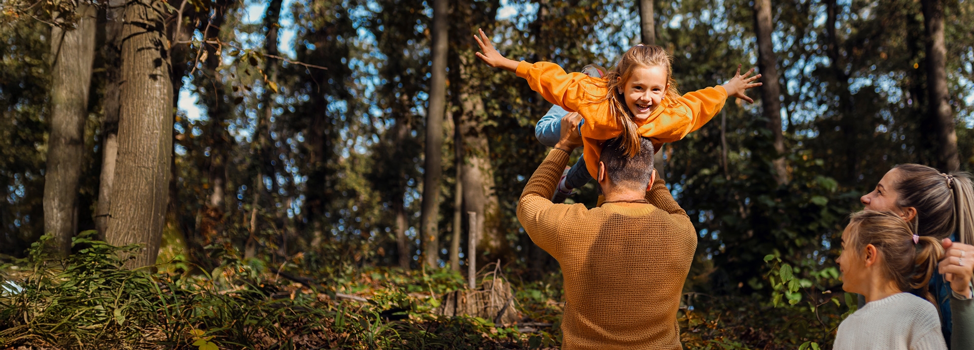 Vrolijk gezin verkent de natuur tijdens een wandeling in het bos.