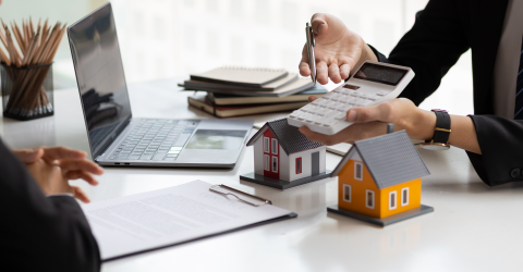 Hypotheekadviseur laat een bedrag op een rekenmachine zien aan de kope