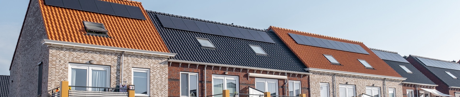 Nieuw gebouwde huizen met zonnepanelen op het dak met op de achtergrond een mooie blauwe lucht